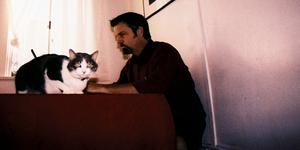 Man and cat at table